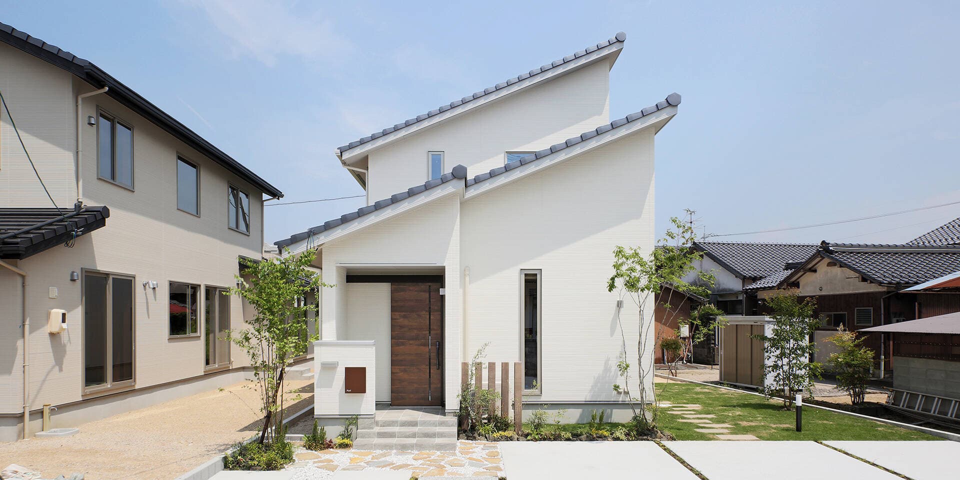 Nhà 2 tầng thiết kế mái dốc với sân cỏ xanh mướt bao quanh 3 mặt