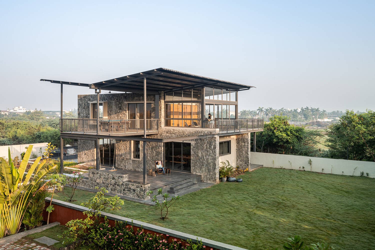 Nhà khung thép ở Ấn Độ tránh nóng hướng Tây bằng cách xây tường đá bazan thô ráp